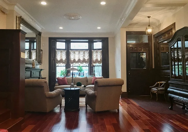 Living Room Remodel: Living room after the remodel, with a bay window, dark wood trim and cherry floors