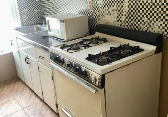 Kitchen before the remodel, with an old gas stove